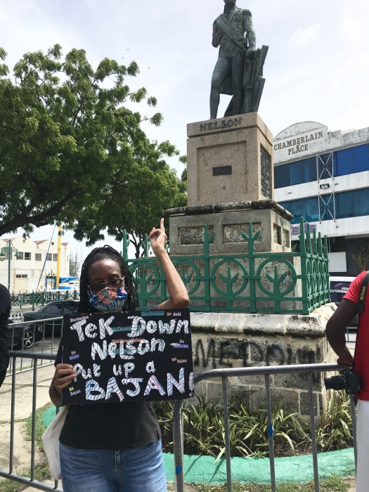 ArtsEtc Editor Linda M. Deane pointing toward the Statue of Nelson in Bridgetown, St Michael, June 2020.
